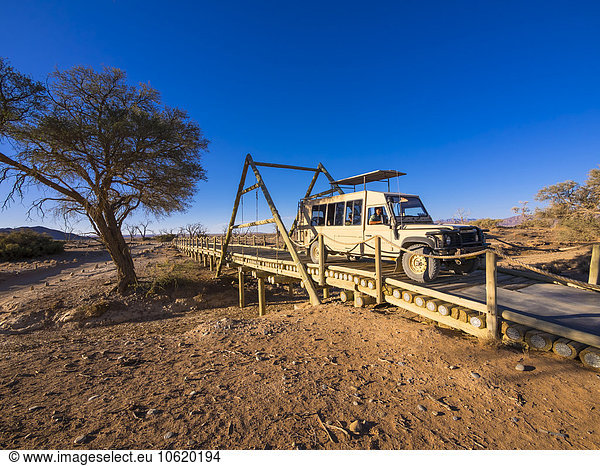 Namibia  Hardap  off-road vehicle crossing wooden bridge at Kulala Wilderness Reserve