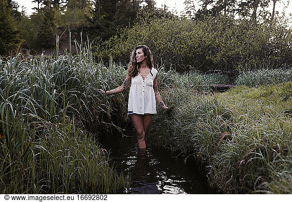 Natural beauty with tattoos in a meadow in Ucluelet