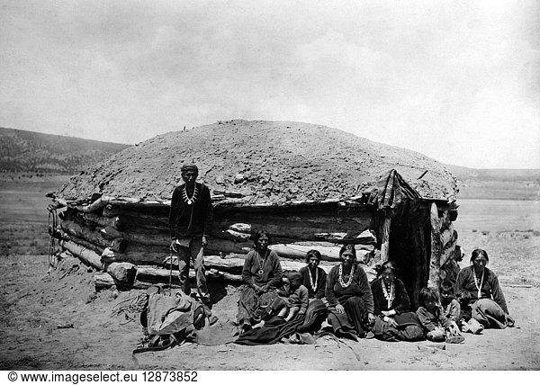 NAVAJO DWELLING  c1906. Dine Tsosi  a Navajo leader  with women and children in front of a hogan  a traditional dwelling  in the southwest United States. Photograph by Simeon Schwemberger  c1906.