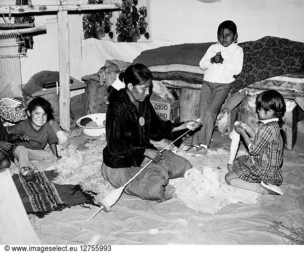 NAVAJO FAMILY  c1970. Rose Yazzie with her children  spinning wool in Canyon de Chelly  Arizona. Photograph by Fred Mang Jr.  c1970.