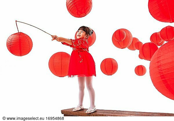 Neben den roten Laternen spielen kleine Mädchen  die eine Laterne tragen