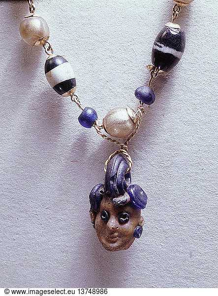 Necklace made of gold and lapis lazuli  The terminal of the necklace is in the form of a female head. Babylonian. Ancient Iraq.