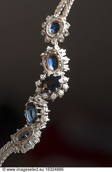 Necklace made of white gold with sapphires and diamonds in front of black background