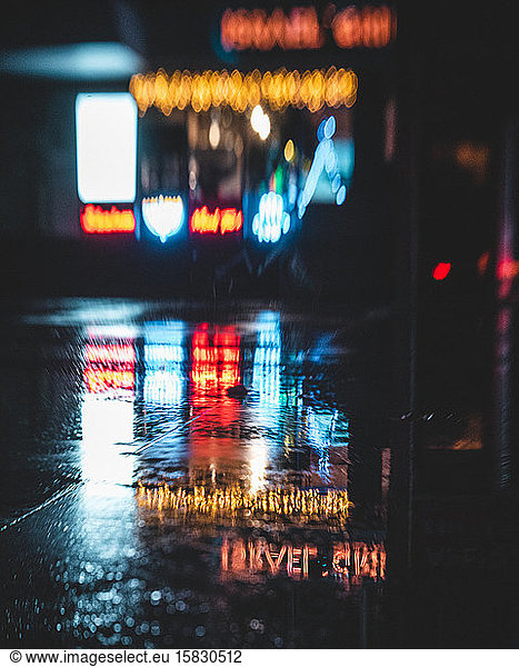 Neon signs reflected in a puddle