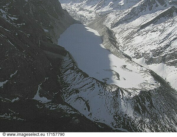 NEPAL Trakarding Glacier -- 16 Apr 2005 -- Ein Luftbild des Tsho Rolpa  eines Gletschersees hoch oben auf dem Trakarding Glacier. Er ist bemerkenswert  da es sich um eines von 21 (Stand 2007) bekannten Gebieten handelt  in denen die Gefahr eines Gletscherüberlaufs besteht - wenn sich das von der Gletscherschmelze stammende Wasser in einem natürlichen See wie dem hier abgebildeten Tsho Rolpa (Chhyugima Pokhari) (Mitte) staut und durch die Moräne bricht und die darunter liegenden Gebiete überschwemmt. Dieser Fall von Gletscherausbruch bedroht viele Kilometer Flusstäler  vor allem entlang des Rolwaling-Flusses und des Tamakhosi-Flusses weiter westlich usw. Erstaunlicherweise war dieser See in den 1960er Jahren nicht viel größer als der durchschnittliche Ententeich! Wissenschaftler haben davor gewarnt  dass der Temperaturanstieg infolge der globalen Erwärmung den Untergang dieser Himalaya-Eisfälle und -Gletscher verursachen könnte. Die Auswirkungen werden wahrscheinlich viele asiatische Länder betreffen  da diese Gletscher - und die Gletscher im benachbarten Tibet - die meisten der großen Flusssysteme von Pakistan bis China speisen. Weitreichende Überschwemmungen haben begonnen und werden voraussichtlich anhalten. Während des Monsuns 2004 waren etwa 30 Millionen Menschen in Nepal  Indien und Bangladesch von schweren Überschwemmungen betroffen. Wissenschaftler fügen hinzu  dass nach dem Abschmelzen der Gletscher ihr Rückzug zu einer weit verbreiteten Dürre in vielen Gebieten Asiens führen wird -- Bild ? Jon Mitchell / Lightroom-Fotos.