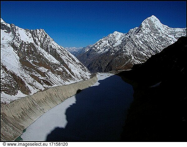 NEPAL Trakarding Glacier -- 16 Apr 2005 -- Luftaufnahme des Tsho Rolpa - eines Gletschersees am Fuße des Trakarding Gletschers  der bemerkenswert ist  da er eines von 13 bekannten Gebieten ist  in denen die Gefahr eines Gletscherüberlaufs besteht - wenn sich das von der Gletscherschmelze stammende Wasser in einem natürlichen See  wie dem hier abgebildeten Tsho Rolpa (Chhyugima Pokhari)  staut (Mitte). Dieser Fall von Gletscherausbruch bedroht viele Kilometer Flusstäler  vor allem entlang des Rolwaling-Flusses und des Tamakhosi-Flusses weiter westlich usw. Wissenschaftler haben davor gewarnt  dass die steigenden Temperaturen infolge der globalen Erwärmung den Untergang dieser Eisfälle und Gletscher im Himalaya verursachen könnten. Die Auswirkungen werden wahrscheinlich viele asiatische Länder betreffen  da diese Gletscher - und die Gletscher im benachbarten Tibet - die meisten der großen Flusssysteme von Pakistan bis China speisen. Erstaunlicherweise war dieser See in den 1960er Jahren nicht viel größer als ein durchschnittlicher Ententeich. Weitreichende Überschwemmungen haben begonnen und werden voraussichtlich anhalten. Während des Monsuns 2004 waren etwa 30 Millionen Menschen in Nepal  Indien und Bangladesch von schweren Überschwemmungen betroffen. Wissenschaftler fügen hinzu  dass nach dem Abschmelzen der Gletscher ihr Rückzug zu einer weit verbreiteten Dürre in vielen Gebieten Asiens führen wird. NB Die in diesem Bild sichtbaren Gipfel sind Kang Nachungo (rechts) und Bamongo (Mitte rechts) -- Bild ? Jon Mitchell / Lightroom Fotos.