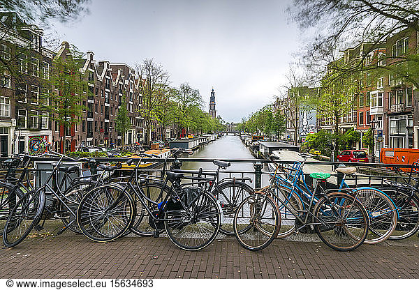 Netherlands  Amsterdam  Bicycles parked along railing of canal bridge