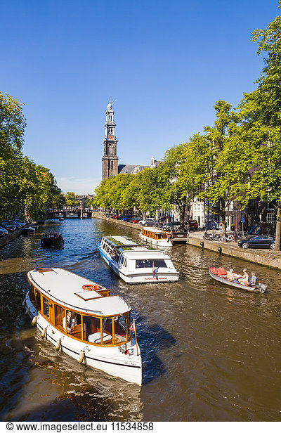 Netherlands  Amsterdam  view to Westerkerk with tourboats on Prinsengracht in the foreground