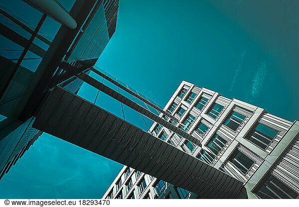 Netherlands  North Holland  Amsterdam  Turquoise sky over elevated walkways stretching between two buildings