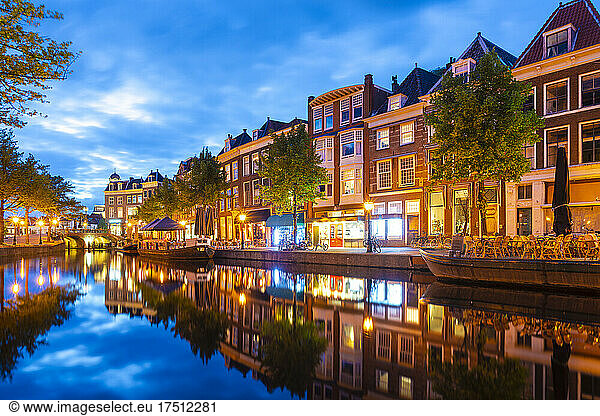 Netherlands  South Holland  Leiden  Row of townhouses reflecting in Nieuwe Rijn canal at dusk