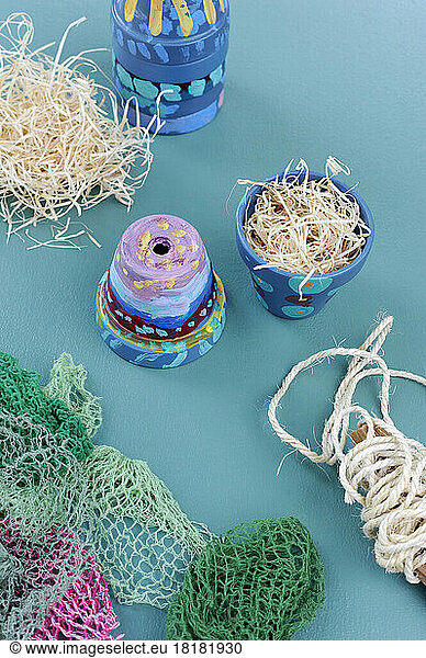 Netting  wood wool and colorful painted terracotta flower pots