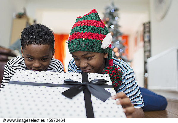 Neugierige Brüder schauen auf Weihnachtsgeschenk
