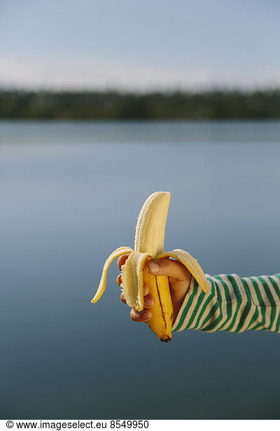 Neunjähriges Mädchen mit biologischer  geschälter Banane