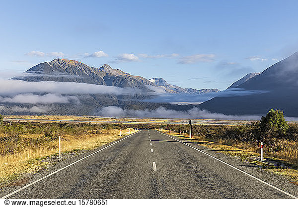 Neuseeland  Nebel schwebt über dem leeren State Highway 73 mit Bergen im Hintergrund