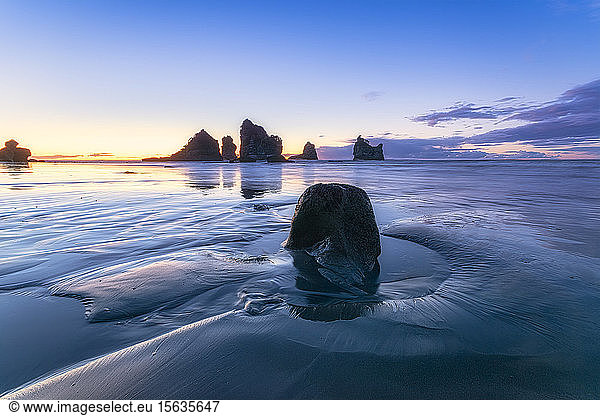 Neuseeland  SÃ?dinsel  Silhouetten von MotukiekieÂ Strand und Meeresstapel bei Sonnenuntergang