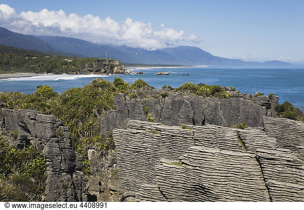 Neuseeland  Südinsel  Westküste  Blick auf Pfannkuchenfelsen mit Meer und Bergen im Hintergrund