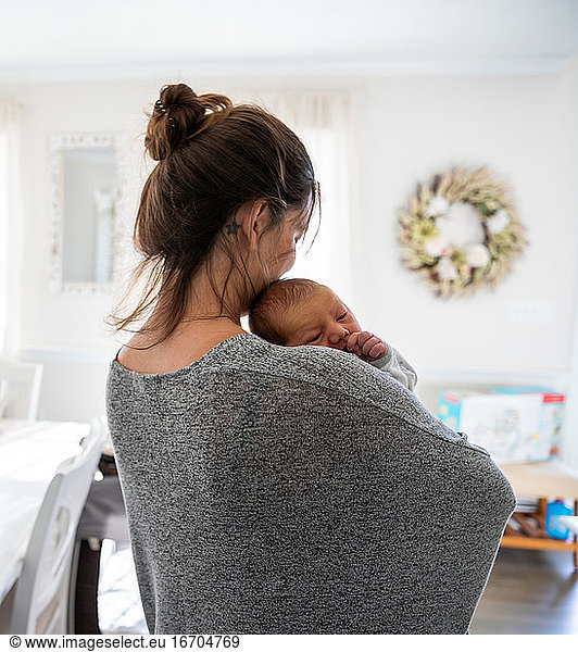 New mother in love holding her newborn baby at home.