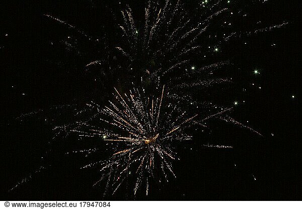 New Year's Eve fireworks night sky with yellow and golden sparks