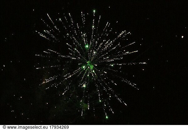 New Year's Eve fireworks night sky with yellow and green sparks