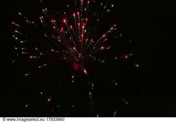 New Year's Eve fireworks night sky with yellow green and red sparks