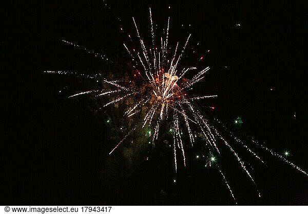 New Year's Eve fireworks night sky with yellow red and green sparks