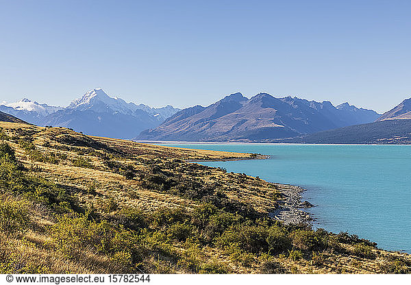 New Zealand  Clear sky over turquoise shore of Lake Pukaki with Mount Cook looming in background