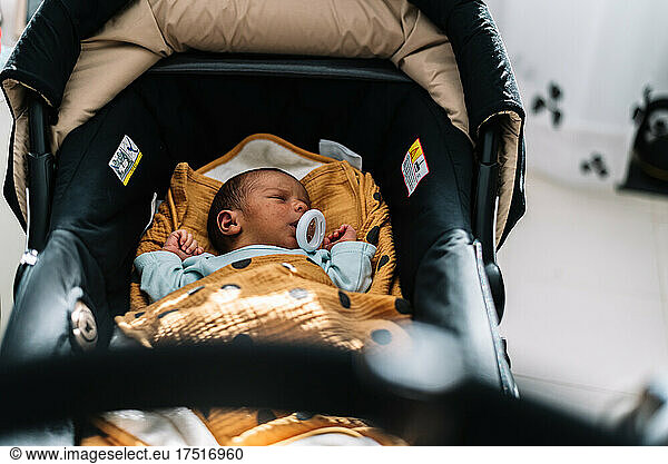 Newborn baby sleeping in his stroller.