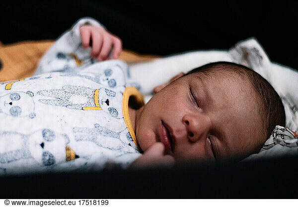 Newborn baby sleeping peacefully in his carriage.