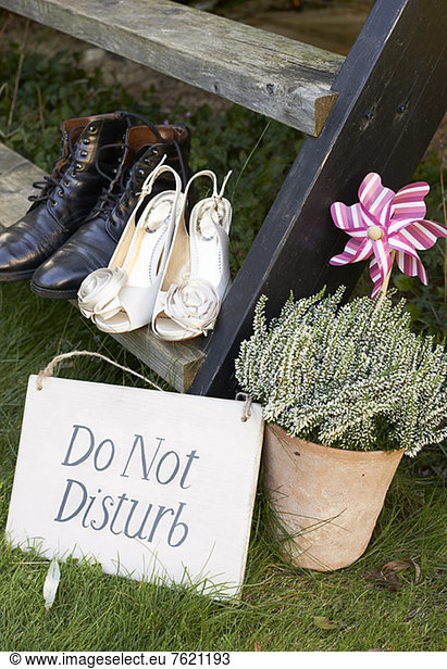 Newlywed couple's shoes with 'do not disturb' sign