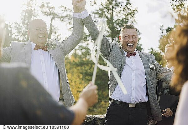 Newlywed gay couple dancing while enjoying with guests at wedding ceremony