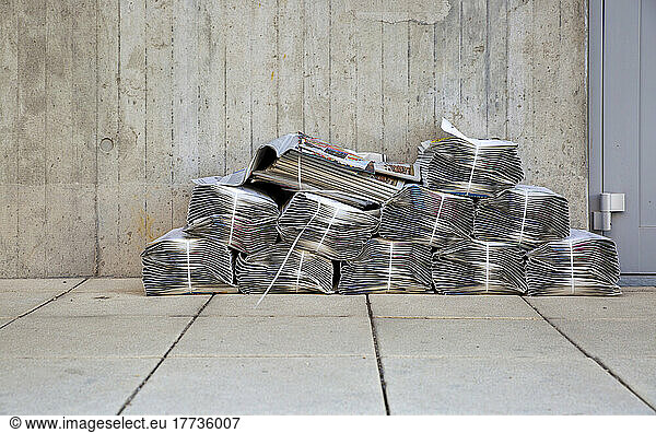 Newspaper stacks lying in front of apartment building