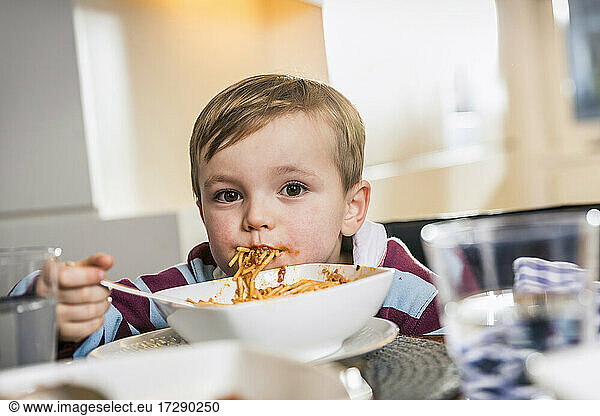 Niedlicher Junge starrt beim Essen zu Hause