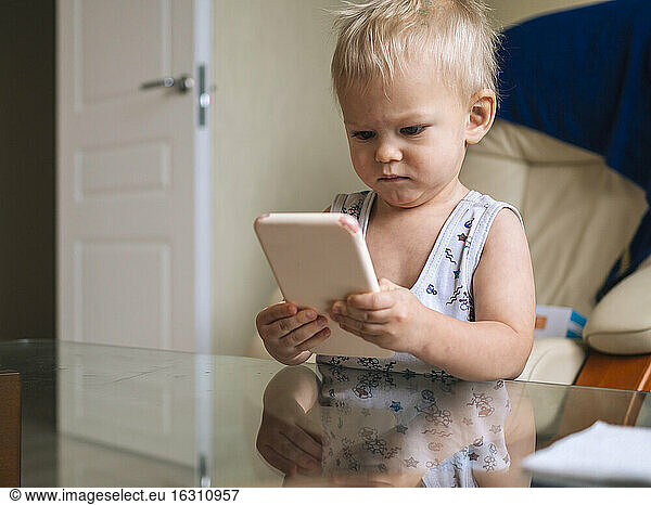 Niedliches Baby schaut auf sein Smartphone