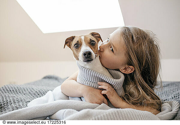 Niedliches Mädchen umarmt Hund zu Hause
