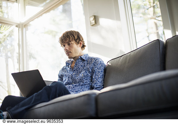 niedrig sitzend Mann sehen Notebook Couch Ansicht Flachwinkelansicht Winkel