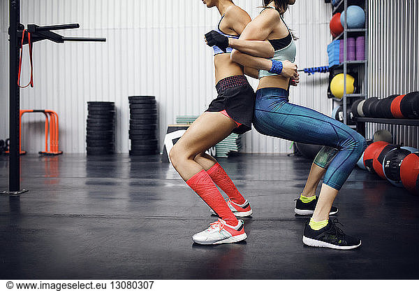 Niedriger Schnitt Seitenansicht von Sportlerinnen  die im Fitnessstudio trainieren
