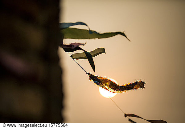 Niedrigwinkel-Nahaufnahme von Gebetsfahnen  die bei Sonnenuntergang im Wind flattern.