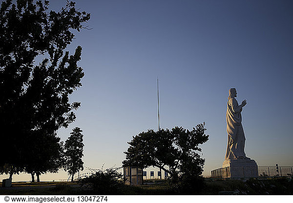 Niedrigwinkelansicht der Jesus Christus-Statue vor klarem blauen Himmel bei Sonnenuntergang