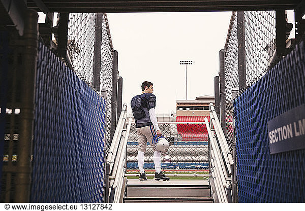 Niedrigwinkelansicht eines am Stadion stehenden American-Football-Spielers durch den Eingang gesehen