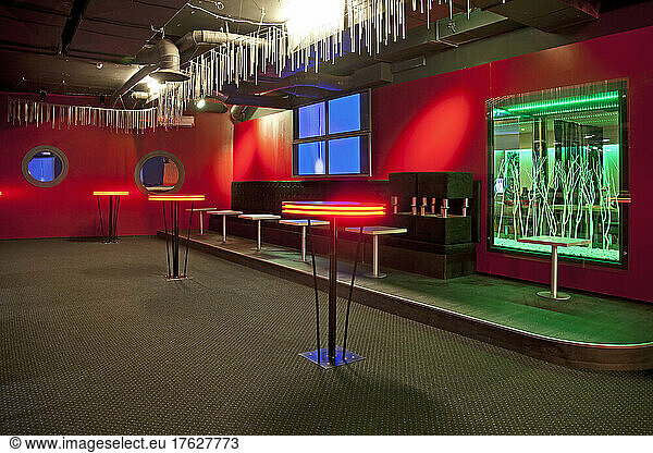 Nightclub interior  hospitality venue and colourful lighting  seatings and tables.
