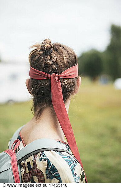 non-binary person with red silk bandana and braided hair at festival
