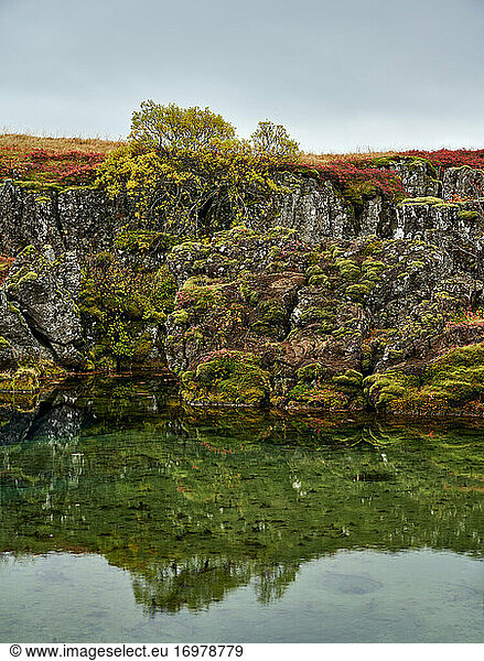 Nordische Herbstlandschaft mit See und felsiger Küste