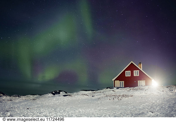 Northern light above red house
