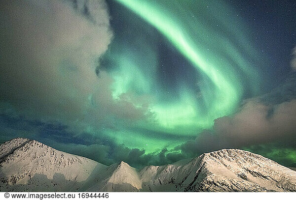 Northern Lights (Aurora Borealis) over mountain peaks covered with snow  Sorvaer  Soroya Island  Hasvik  Troms og Finnmark  Norway  Scandinavia  Europe