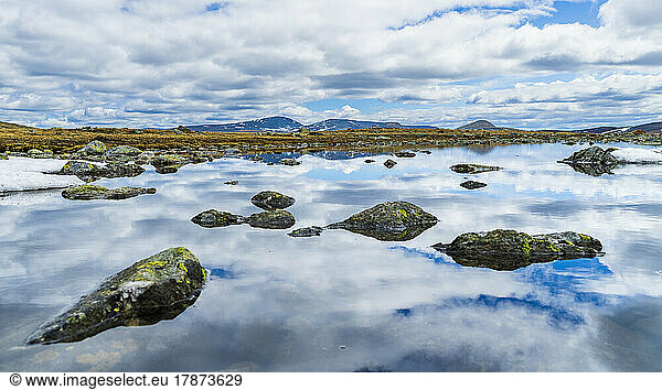 Norway  Innlandet  Clouds reflecting on surface of river flowing in Jotunheimen National Park