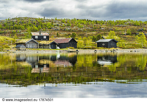 Norway  Innlandet  Secluded huts on lakeshore in Jotunheimen National Park