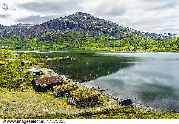 Norway  Innlandet  Secluded huts on lakeshore in Jotunheimen National Park