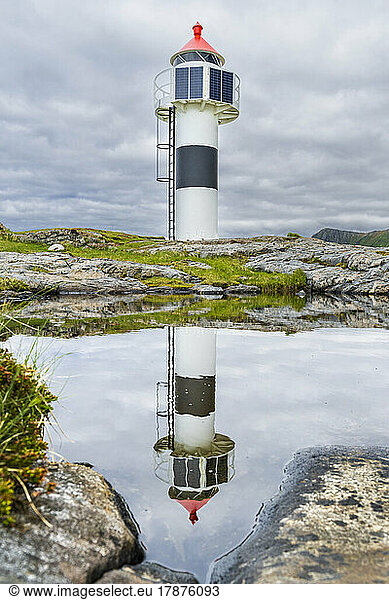 Norway  Nordland  Lighthouse reflecting in coastal water