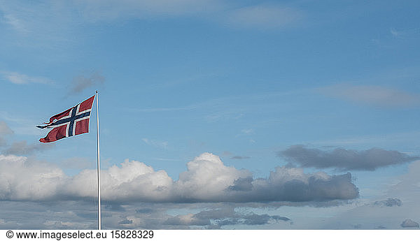 Norwegische Flagge weht am Himmel in Norwegen