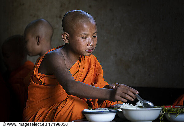 Novice monk eating lunch at Ko Yin Lay Monastery near Kengtung  Myanmar